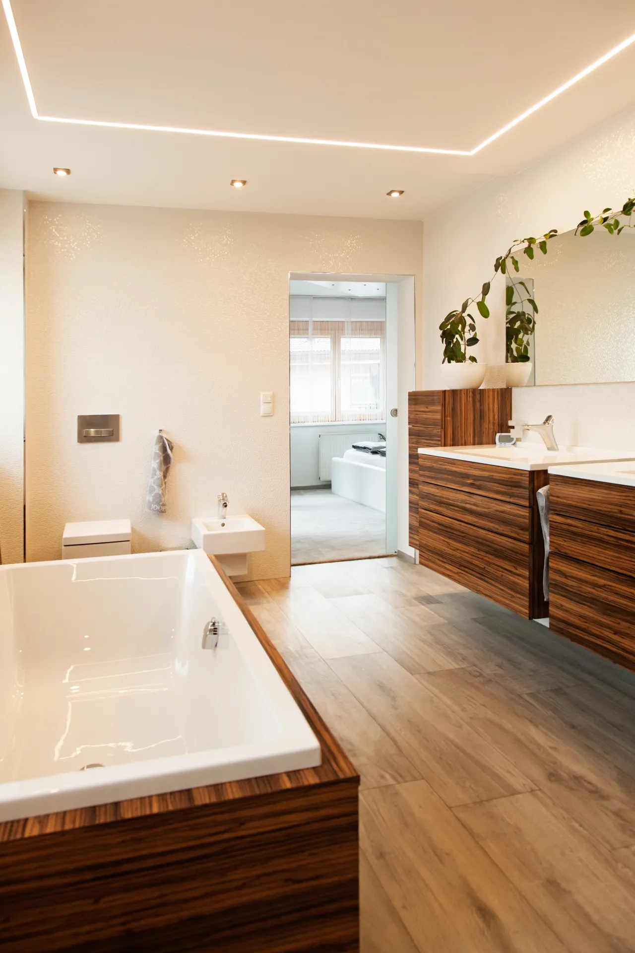 Badezimmer mit Holzmöbeln und freistehender Wanne
